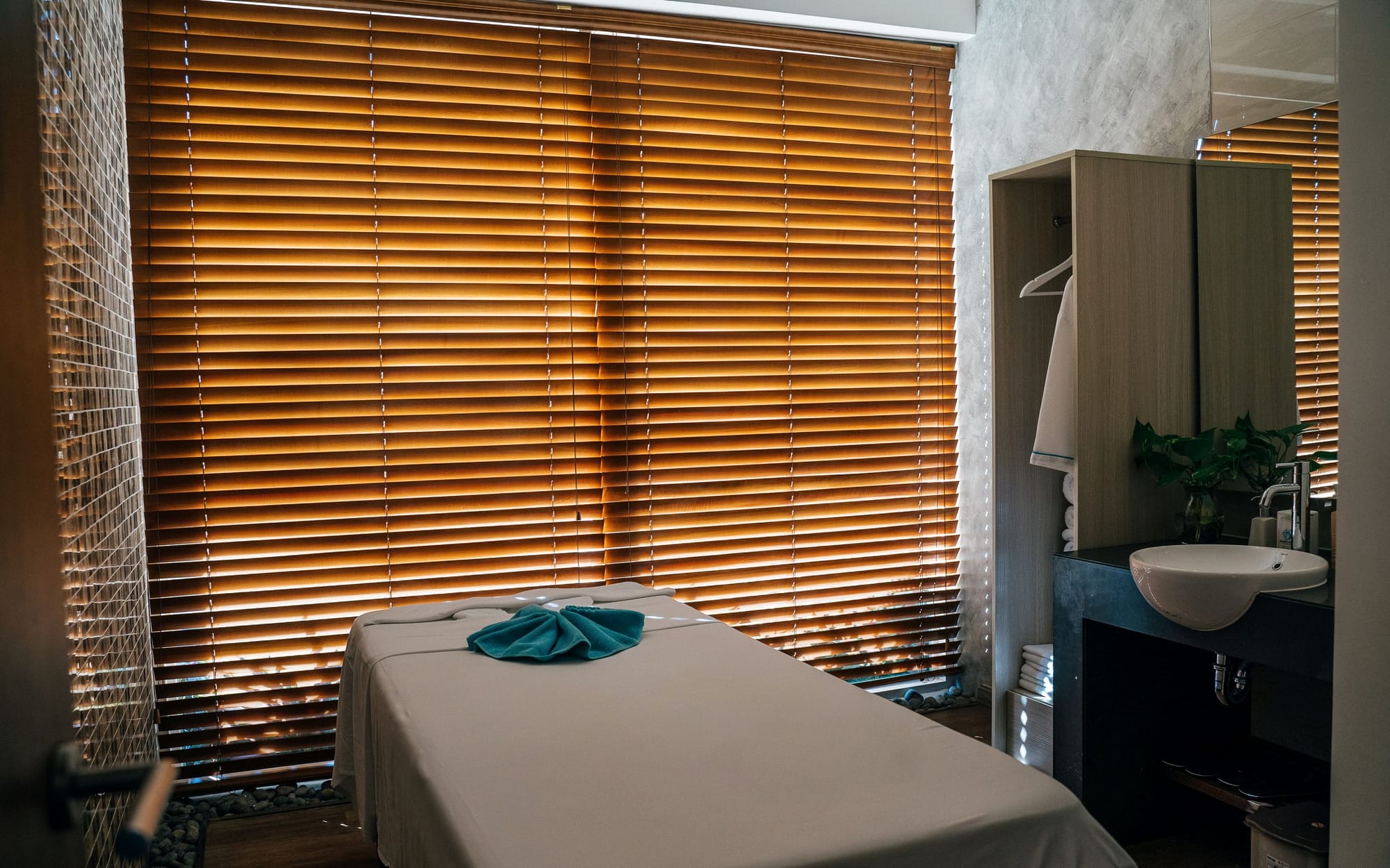 A dressed massage table set up beside a window with the light low at dusk